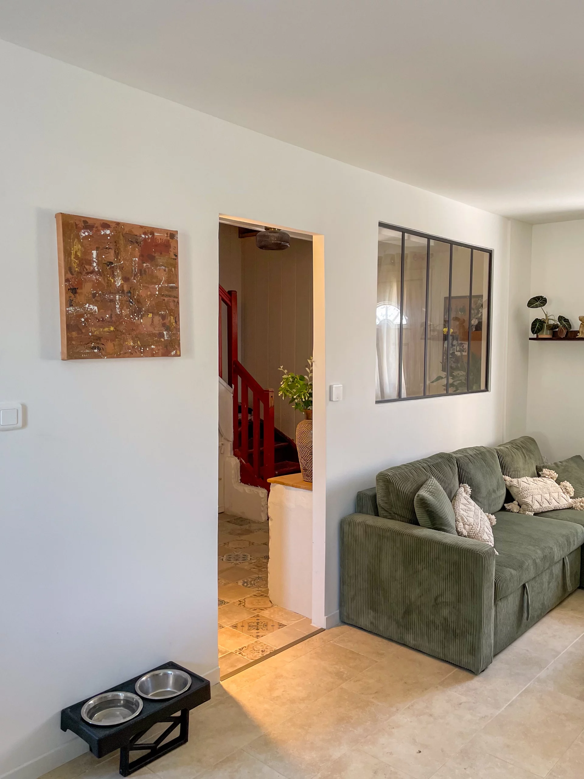 Salon rénové avec mur blanc et décoration épurée